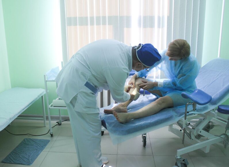 The surgeon examines the patient's veins before performing the operation.